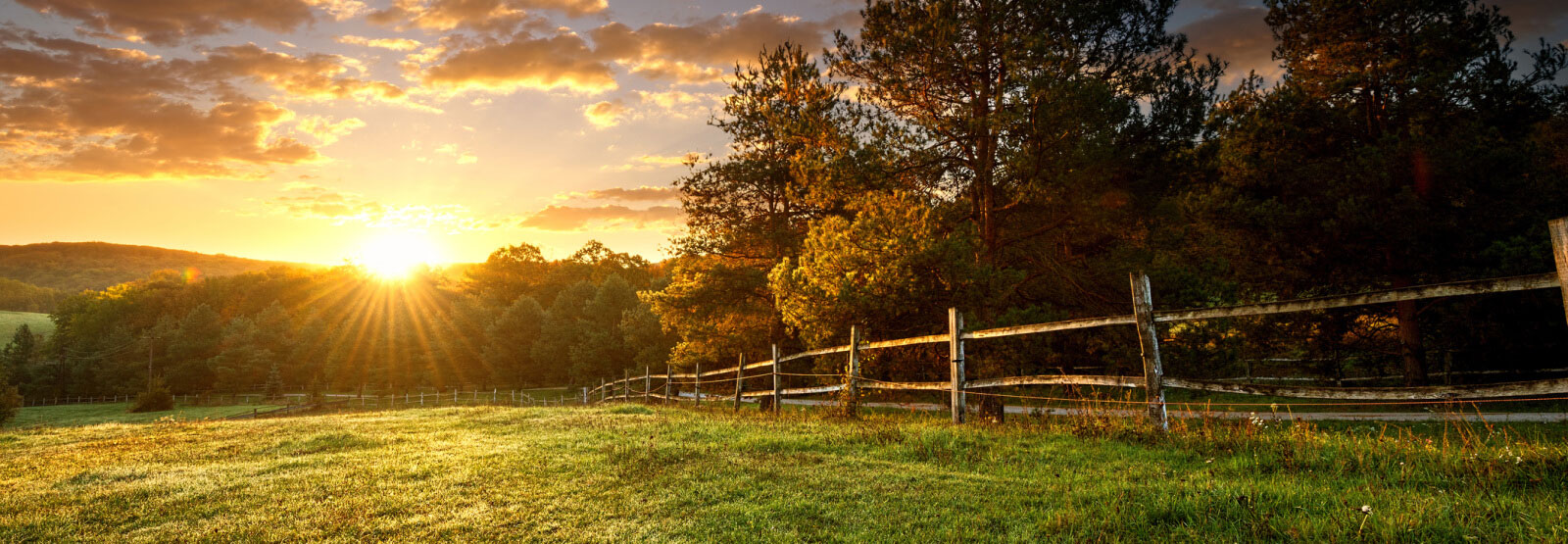 A landscape shot with an old wooden fence and sunset