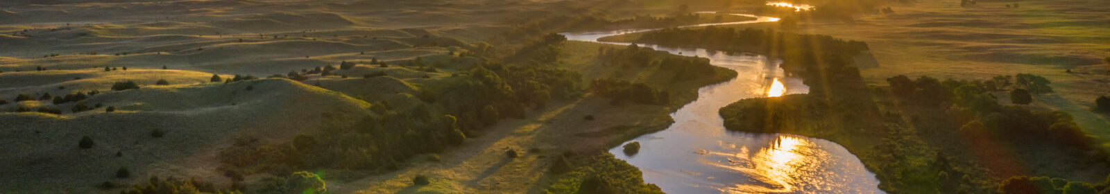 aerial shot of a river running through rural fields
